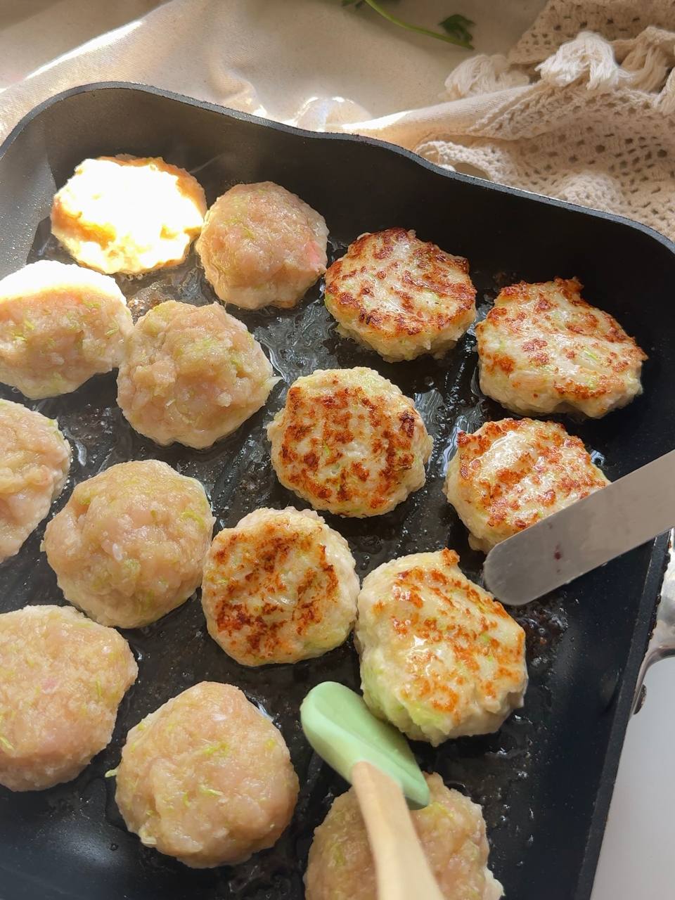 flipping golden chicken zucchini patties in the skillet