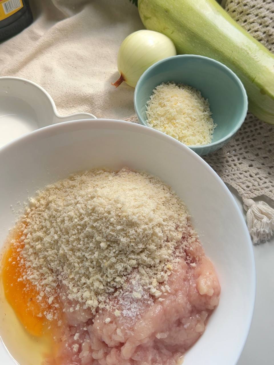 ground chicken with egg, breadcrumbs, salt, and seasoning in a mixing bowl