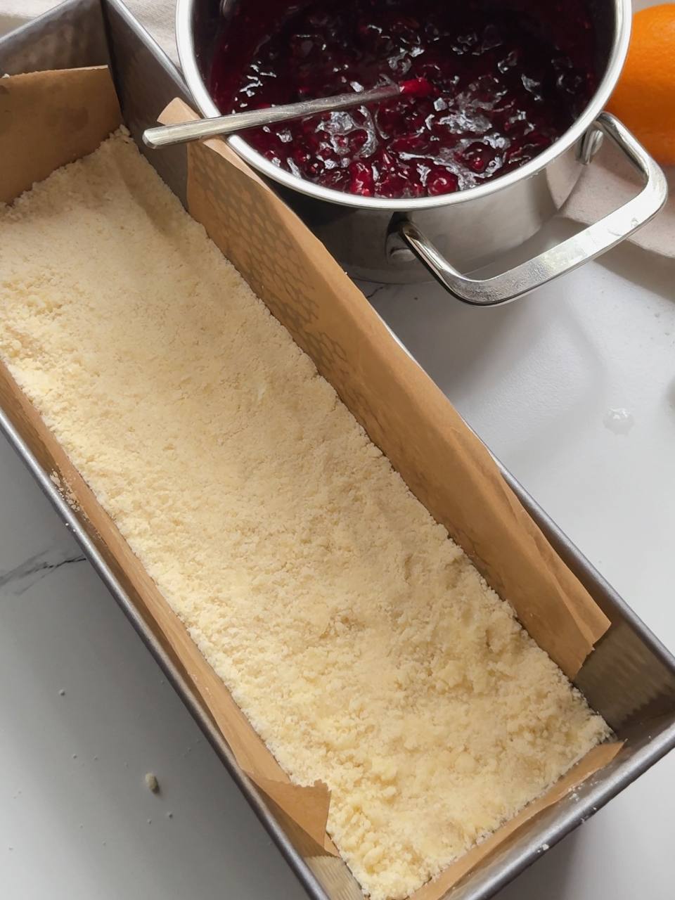 pressing the crumble mixture into the baking pan