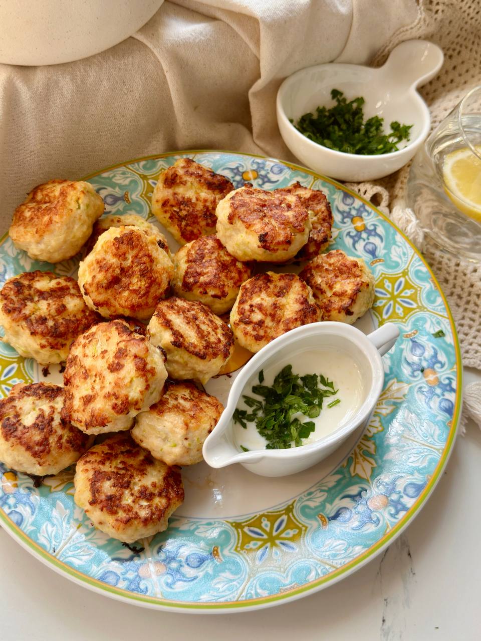 served chicken zucchini patties with garlic sauce and fresh parsley