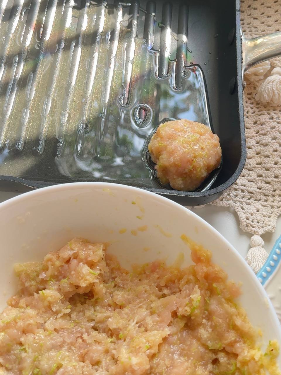 shaping a chicken zucchini patty with wet hands and placing it in a skillet