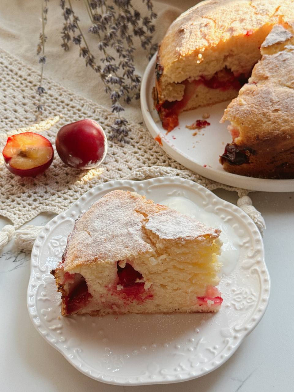Slice of moist Greek yogurt plum cake with fresh plums