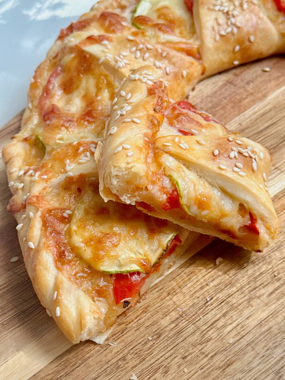 slice of zucchini puff pastry tart with mozzarella and tomatoes