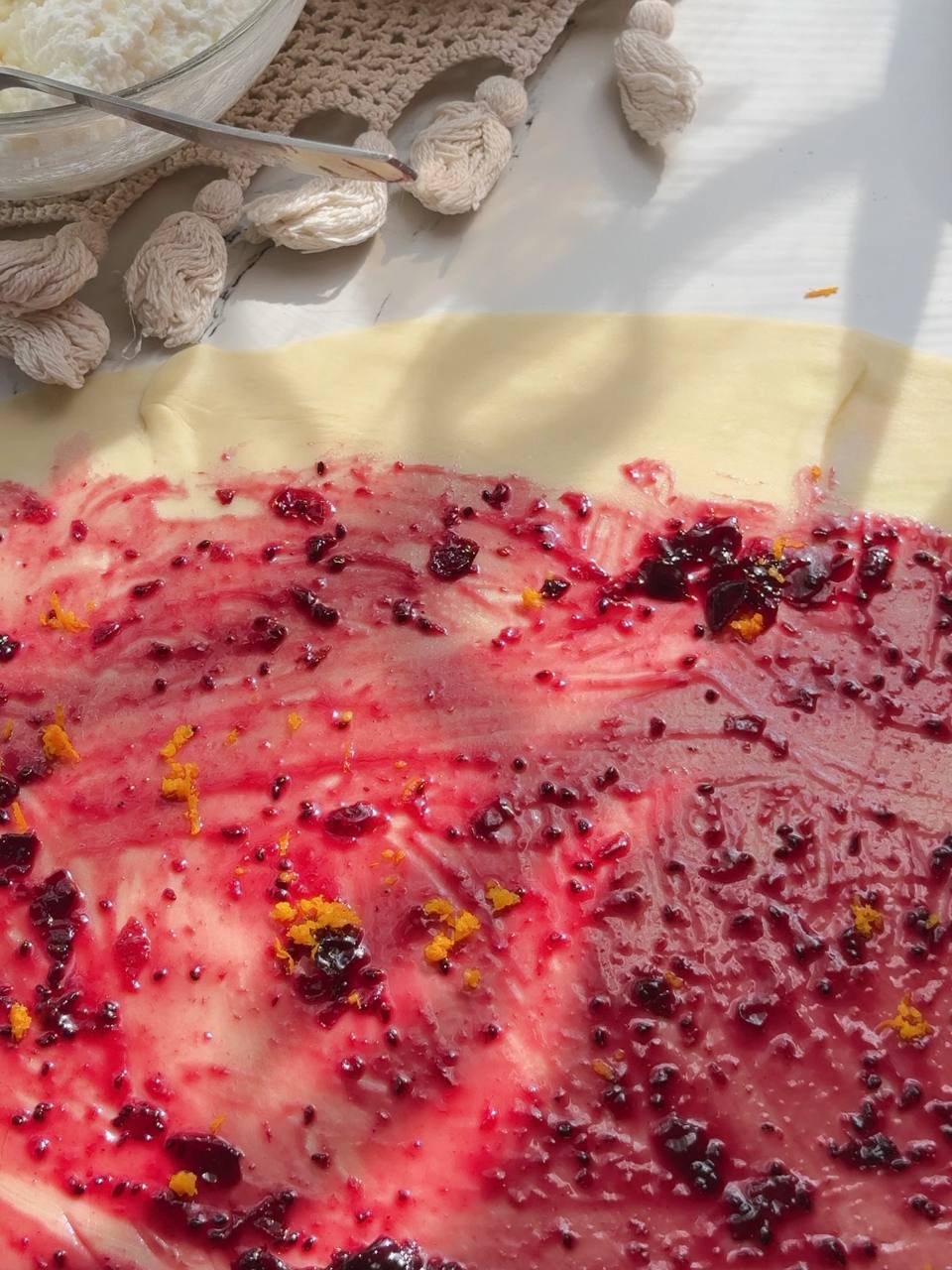 Blackcurrant jam and fresh lemon zest spread over puff pastry