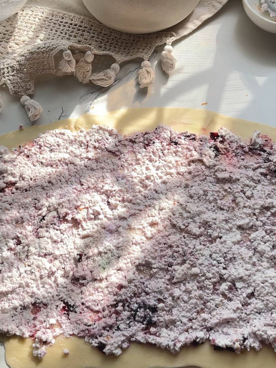 Cottage cheese filling spread over blackcurrant jam on puff pastry