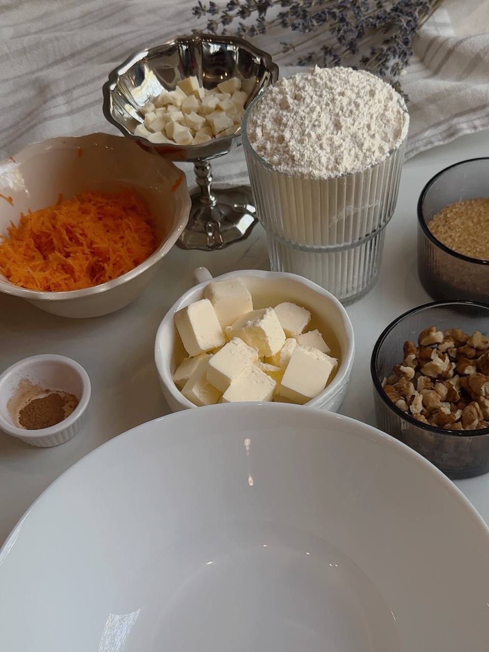 ingredientsIngredients for carrot cake cookies with grated carrot, walnuts, butter, brown sugar, flour, and white chocolate