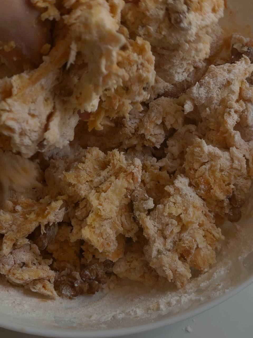 Mixing thick carrot cookie dough with chopped walnuts