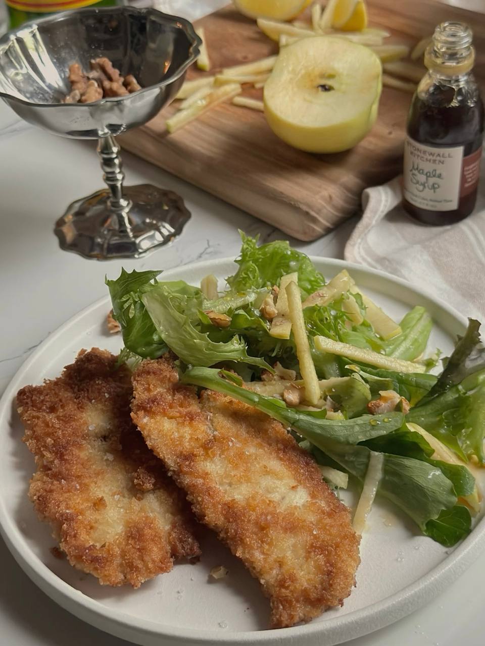 Golden crispy chicken with panko breading served alongside fresh green apple salad with walnuts and honey mustard dressing.