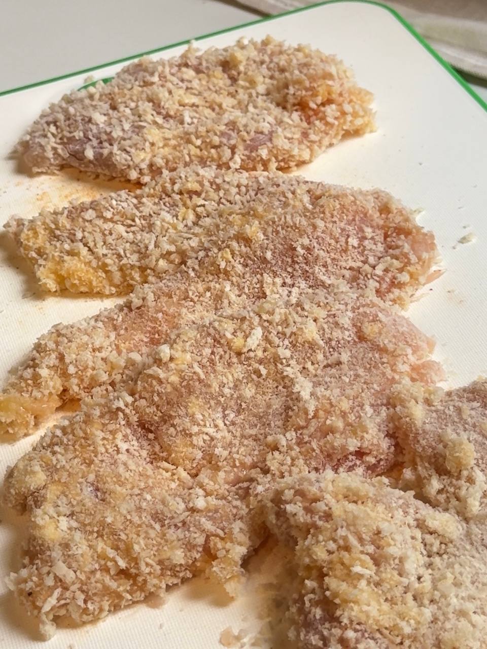 Thin chicken breast cutlets evenly coated in panko breadcrumbs and ready to be pan-fried until golden.