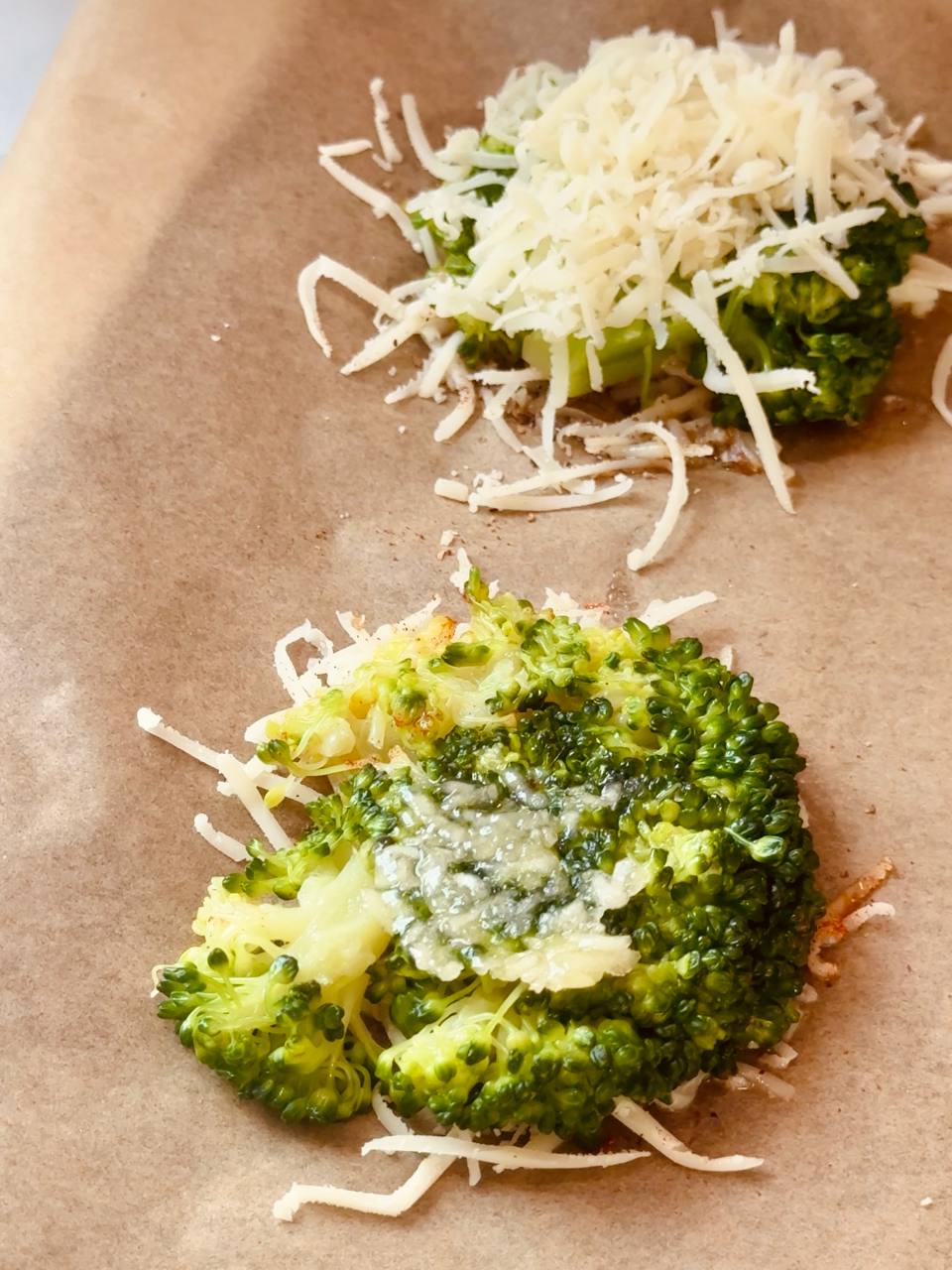 Smashed broccoli topped with freshly grated garlic before baking.